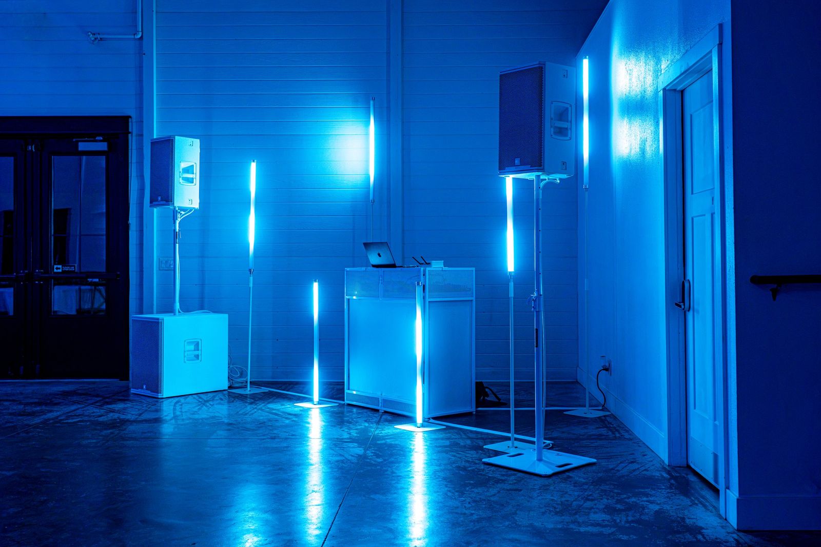 DJ booth, speakers and light tubes set up in blue
